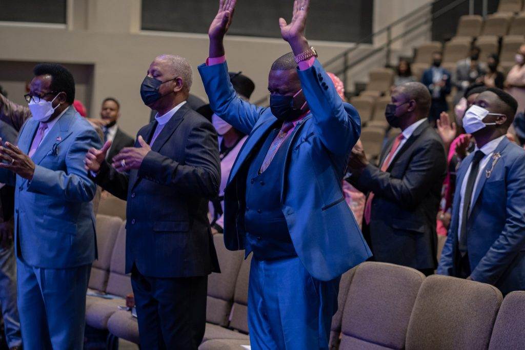 Apostolic congregation applauding in a church.