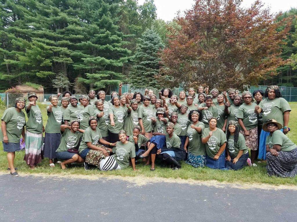 A group of apostolic women in green shirts posing for a photo.