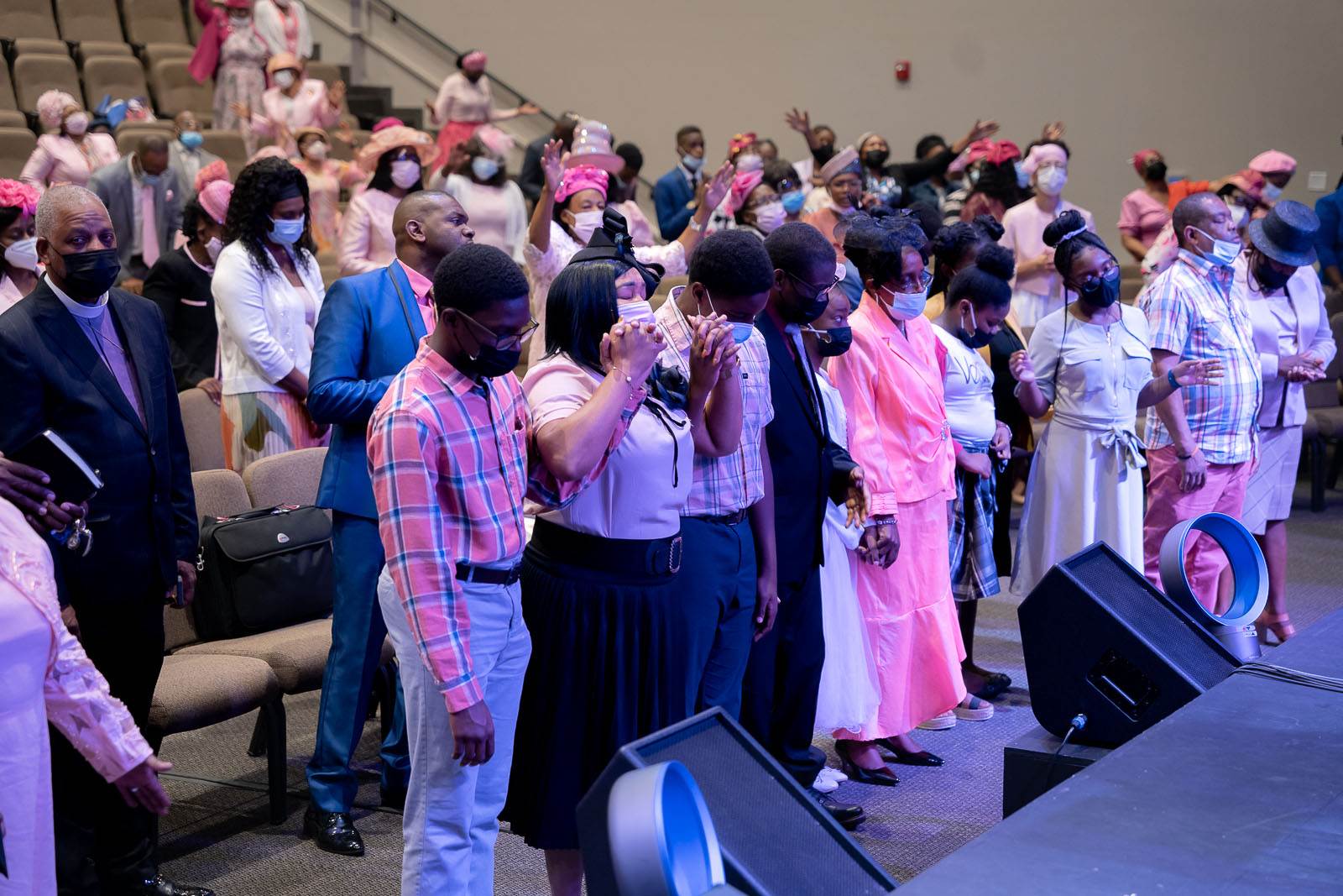 A group of apostolic church members standing in front of a stage.