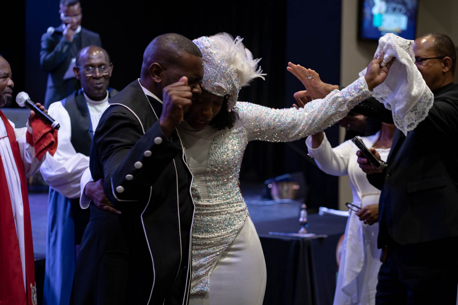 A man and a woman dressed in formal attire at a church ceremony.