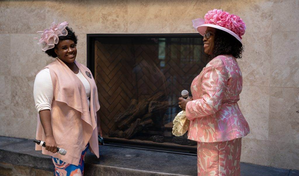 Two apostolic women standing in front of a fireplace.